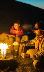 father and son bonding around a fire at a rites of passage camp