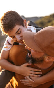 son on fathers back playfully bonding